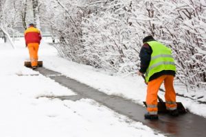 Workers removing first snow from pavement